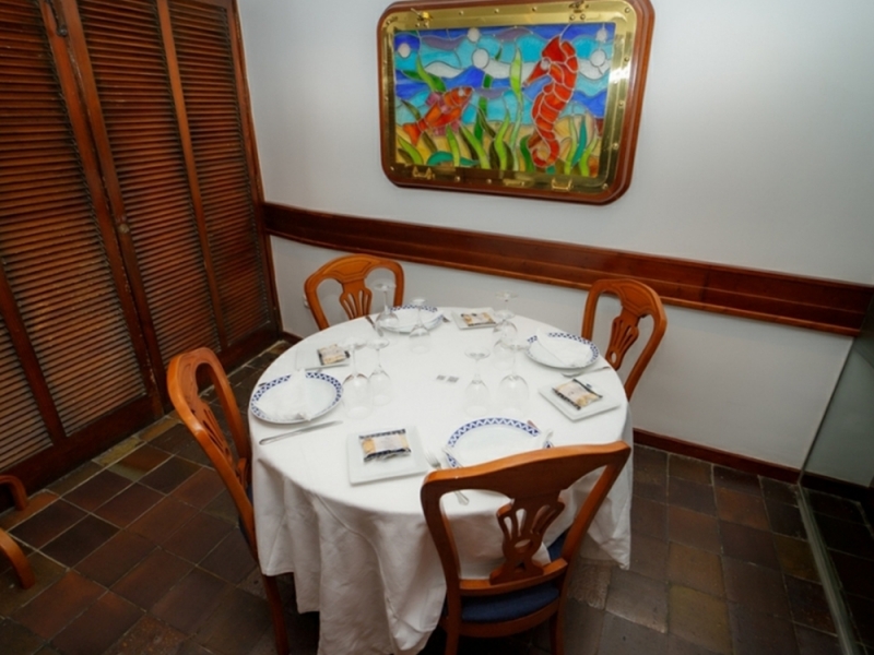 Mesa preparada en el comedor de Civera, bajo una vidriera de caballito de mar