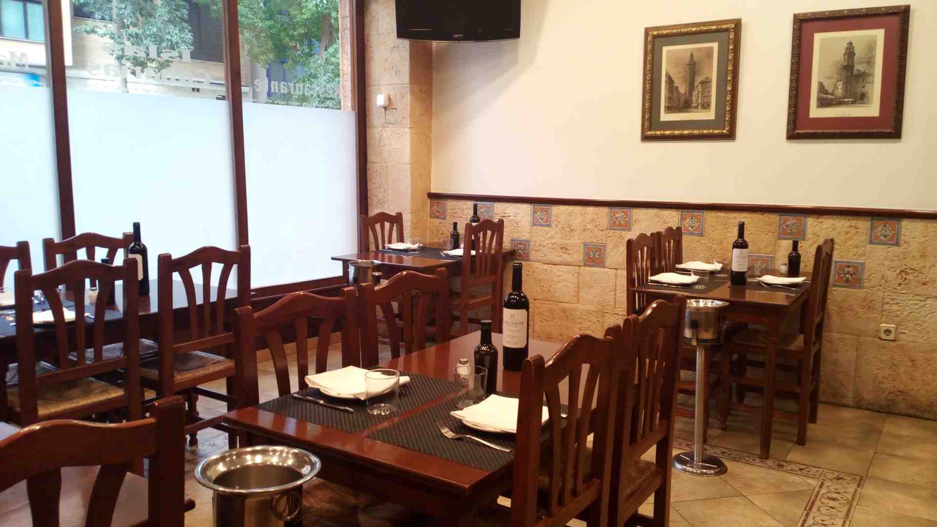 Sala interior del Restaurante Islas Canarias con mesas preparadas y vinos