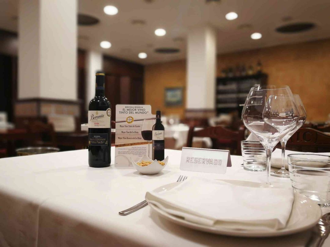 Mesa reservada con mantelería blanca y vino Rioja en el Restaurante Islas Canarias