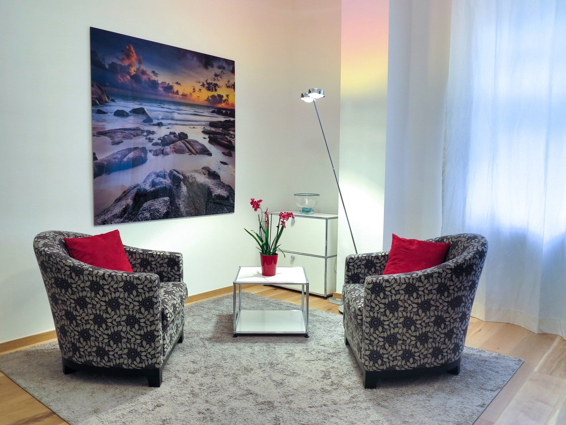 Sala de estar con sillones tapizados a medida, cojines rojos y mesa de centro, fabricada por MR Muebles