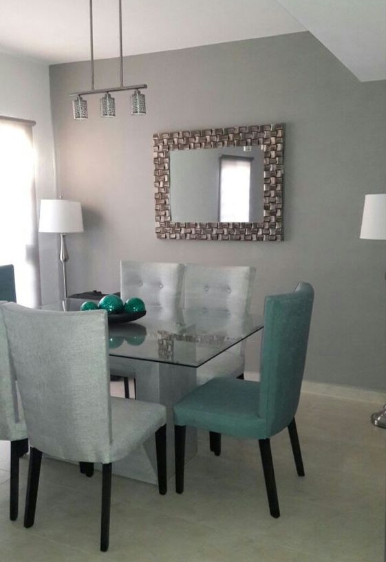 Comedor de vidrio con sillas tapizadas y espejo decorativo, disponible en Muebles Casa sobre la Roca