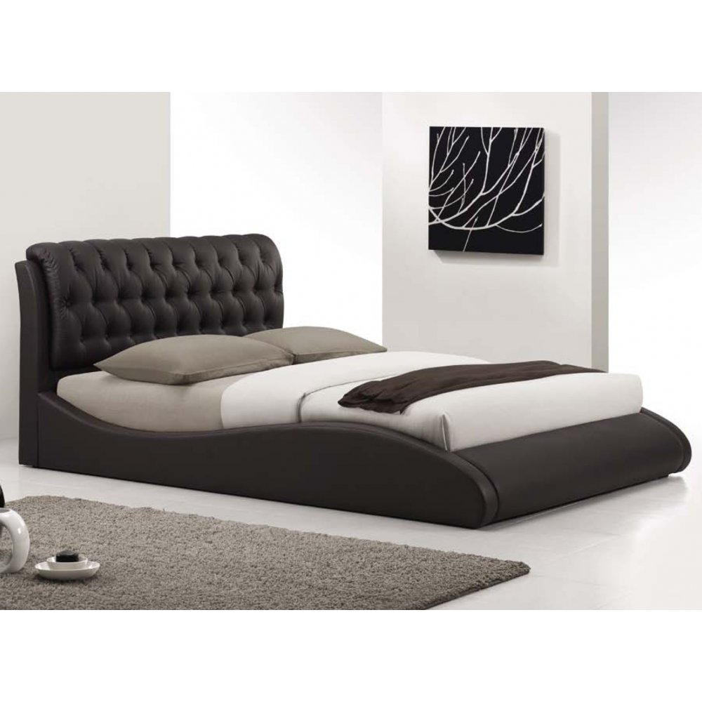 Cama con cabecero curvo tapizado en color oscuro, disponible en Casa sobre la Roca