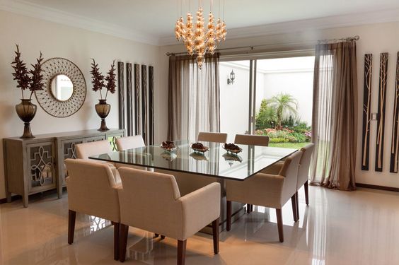 Comedor con lámpara colgante y vista a jardín, disponible en Casa sobre la Roca