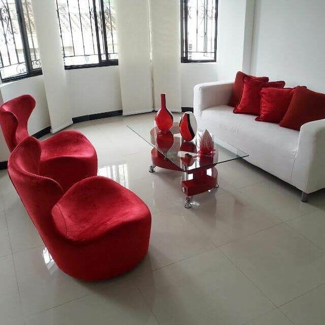 Sala en tela roja con sofá blanco y mesa de centro, disponible en Casa sobre la Roca