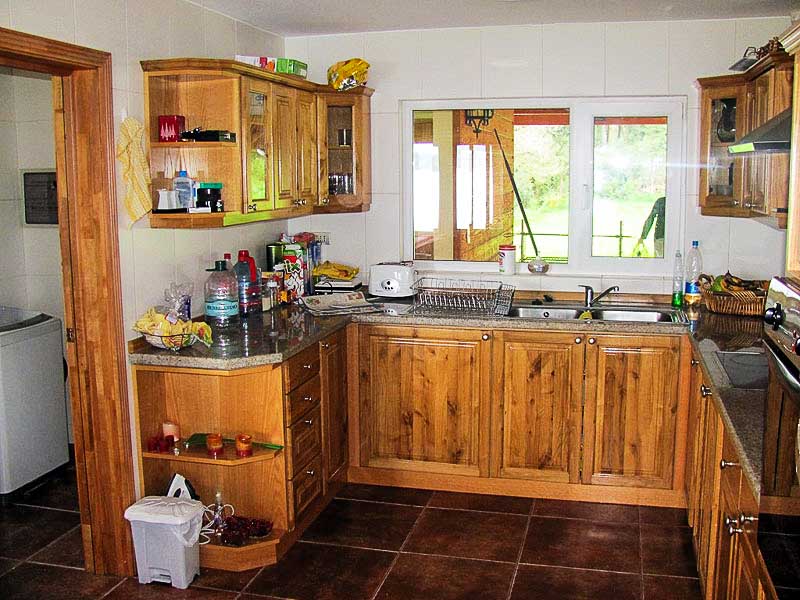 Cocina de madera nativa fabricada a medida por Muebles HZ, con alacenas, repisas y mesón
