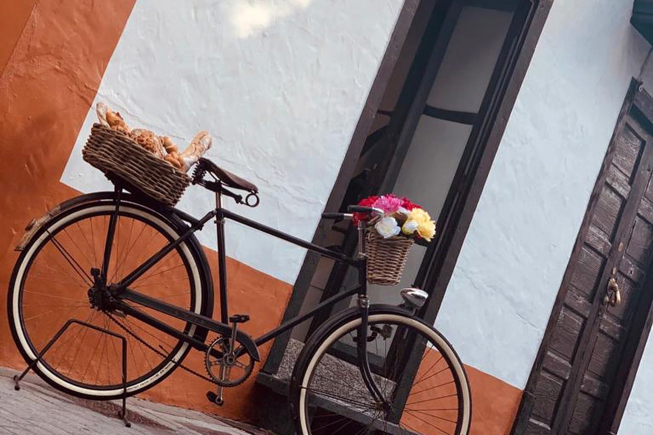 Bicicleta decorativa con cesta de pan frente a fachada tradicional canaria