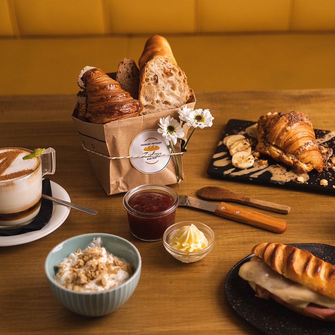 Desayuno de Panadería Zulay con bolsa de pan de marca propia, mermelada y café
