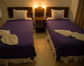 Habitación doble de la Posada Churum Merú con ropa de cama color violeta