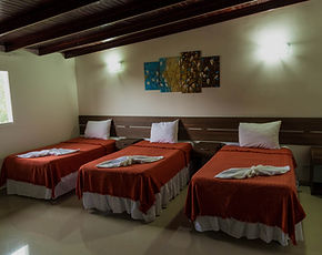 Habitación triple de la Posada Churum Merú con tres camas individuales y decoración artesanal
