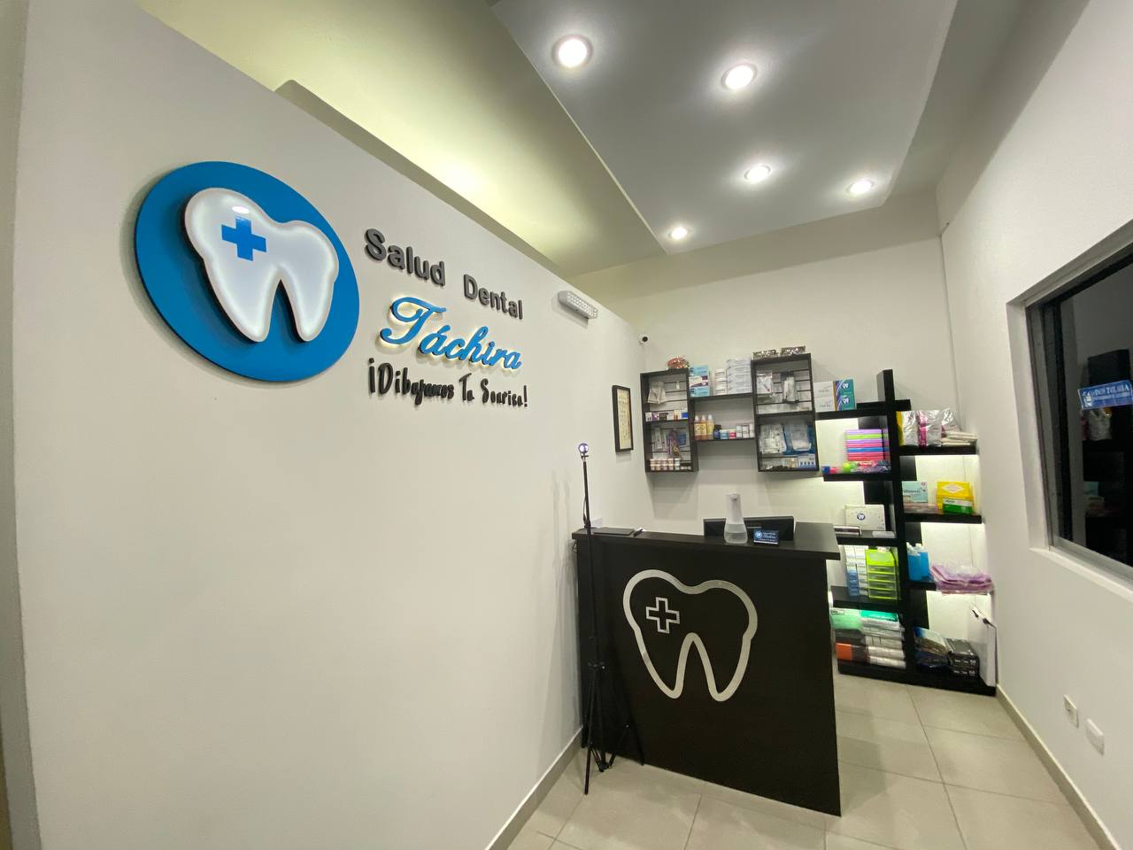 Recepción de Salud Dental Táchira con el logotipo de la clínica en la pared
