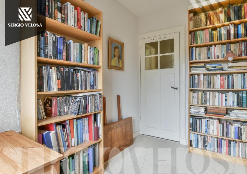 Biblioteca a la medida en madera clara con repisas abiertas y libros, proyecto de Sergio Velosa