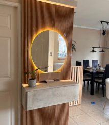 Consola flotante con espejo circular retroiluminado, fabricada por Sobel Muebles