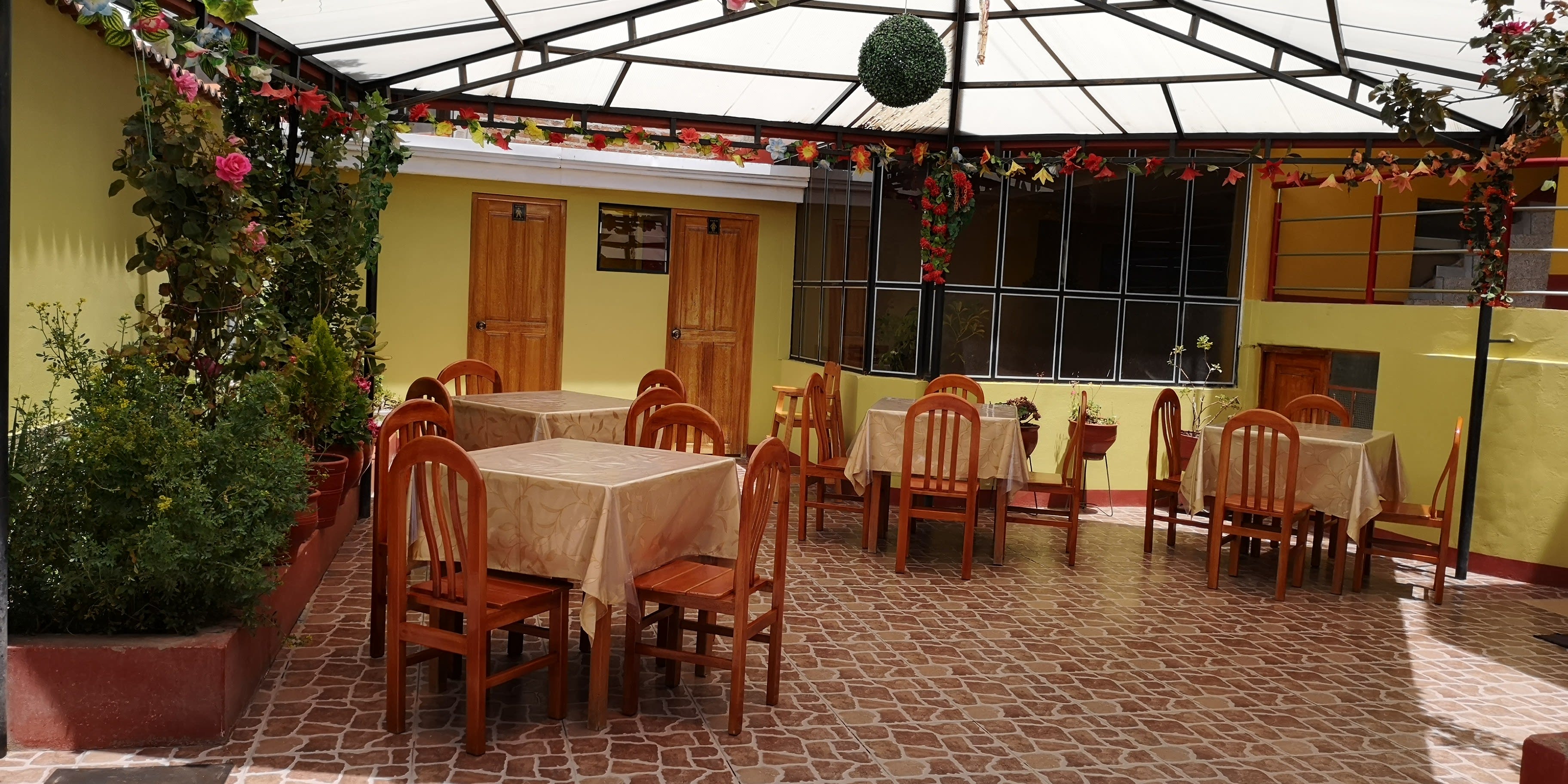 Terraza jardín techada de Restaurant Sombreritos con mesas y flores