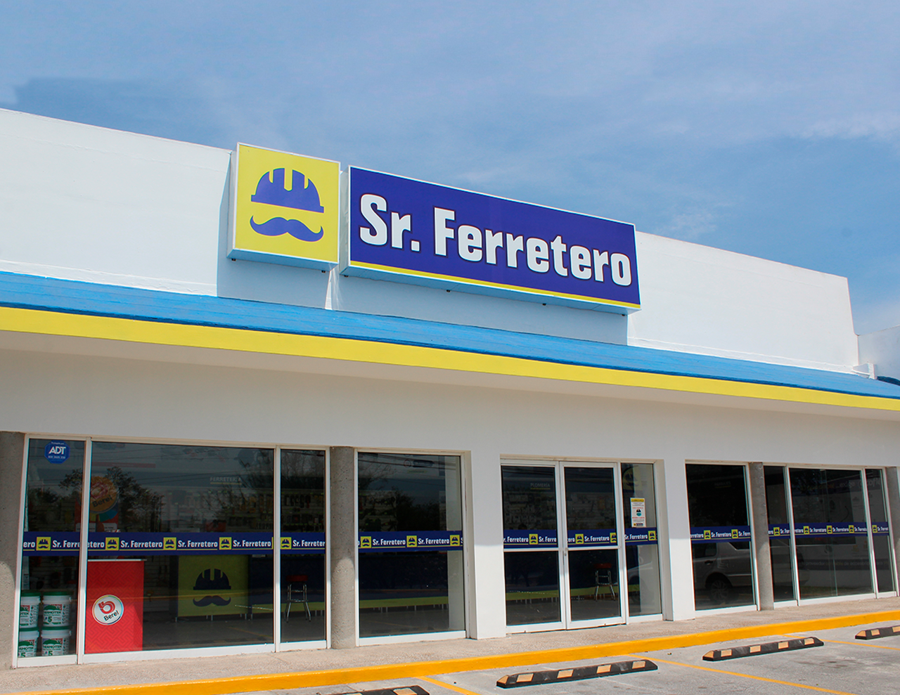 Fachada de Sr. Ferretero con jardineras y cajones de estacionamiento