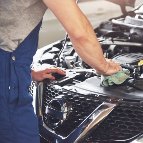 Mecánico de Taller Fortuna trabajando en el compartimento del motor de un vehículo