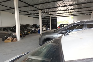 Interior del Taller Solumec cubierto, con varios vehículos en servicio en El Porvenir, Bucaramanga