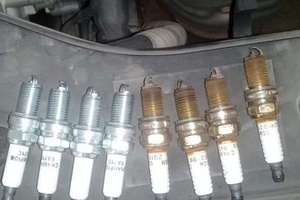 Comparación de bujías nuevas y usadas retiradas de un motor en Taller Solumec