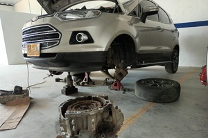 Vehículo Ford levantado con la rueda desmontada para revisión en Taller Solumec
