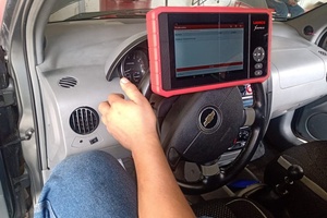 Mecánico usando escáner computarizado para diagnosticar un vehículo en Taller Solumec