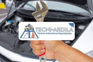 Mano sosteniendo una llave de mecánico frente a un carro con el capó abierto en Tecniardila