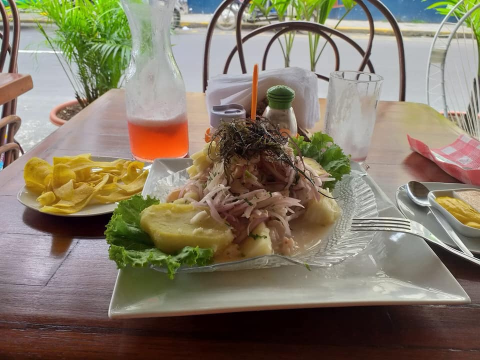 Ceviche criollo servido en plato cuadrado con camote, choclo y chifles en una mesa de The Yellow Rose of Texas