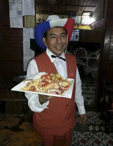 Mesero con sombrero vaquero tricolor sirviendo un plato en The Yellow Rose of Texas