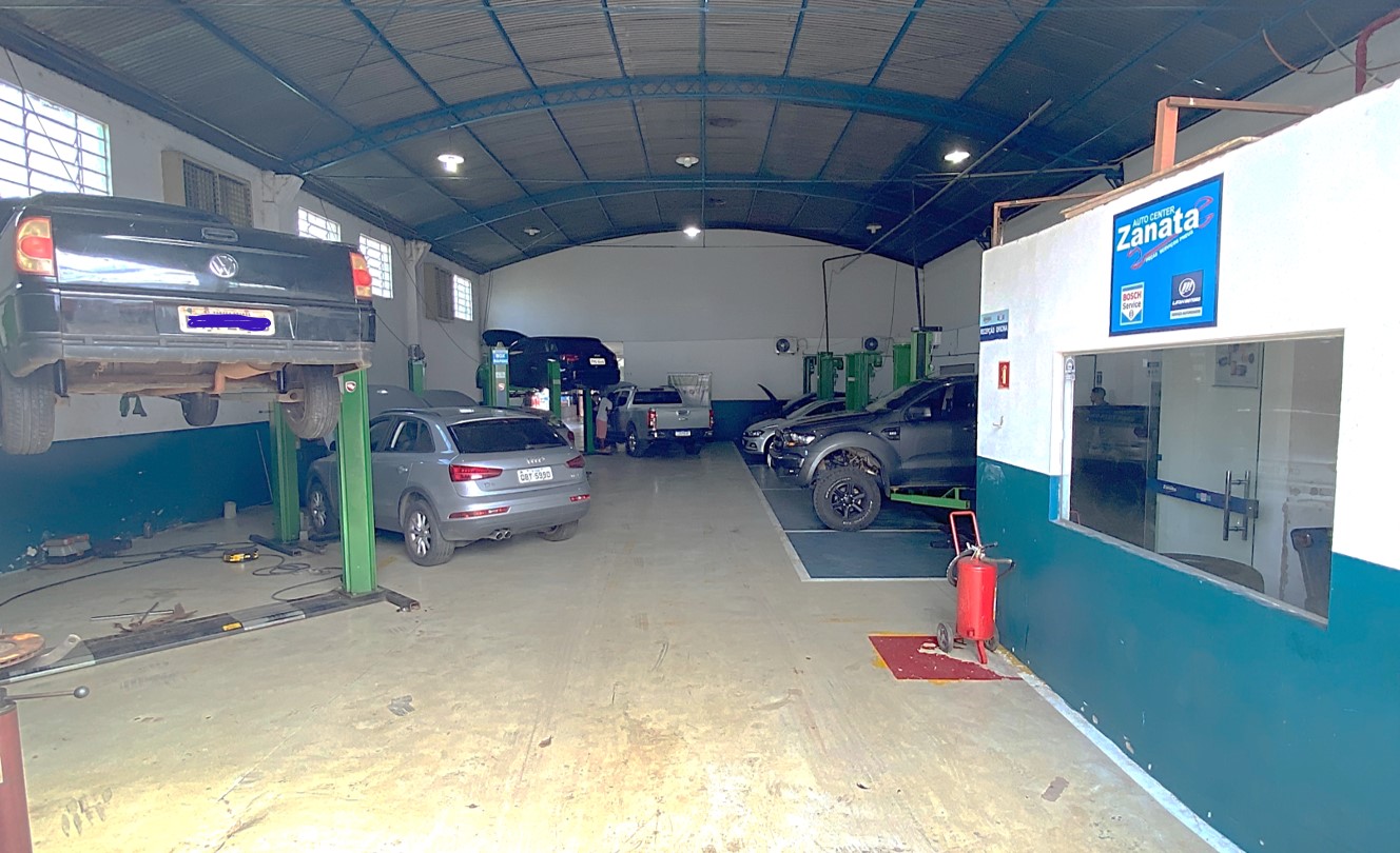 Interior da oficina Zanata Auto Center em Cuiabá com veículos elevados e sinalização Bosch Car Service